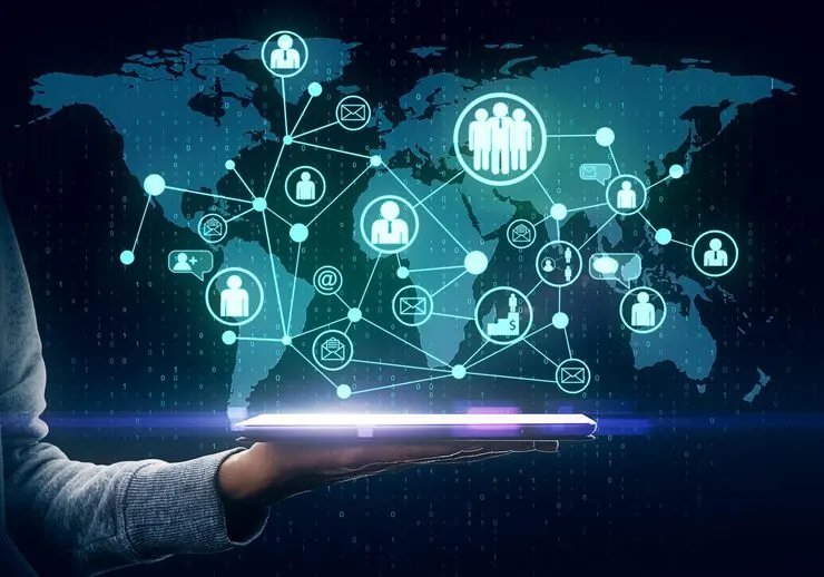 Hand holding tablet with glowing social network map dark background global hiring concept