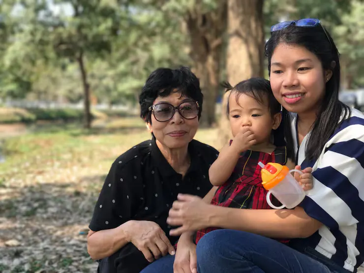 Close up family sitting against trees park