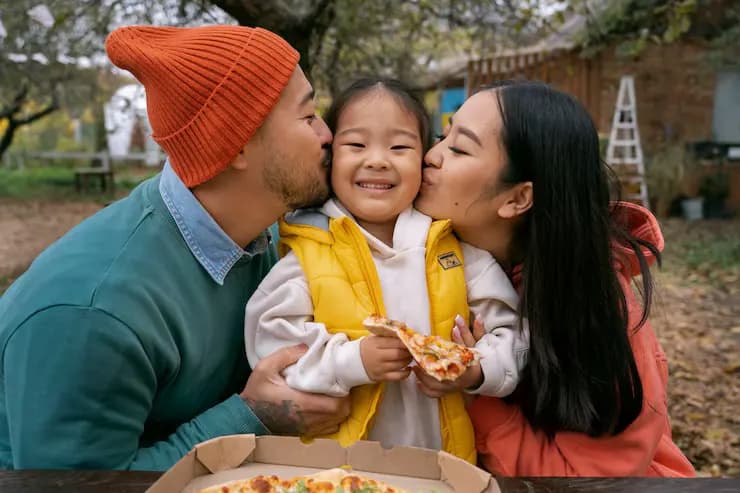 Front view smiley family with pizza