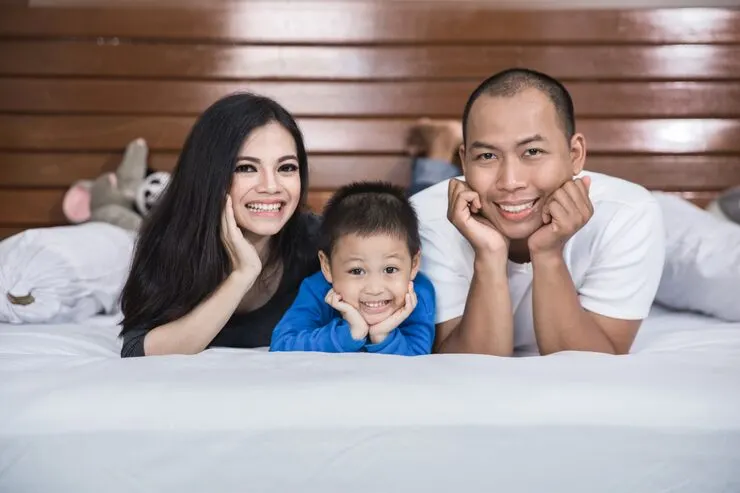 Happy asian family bed
