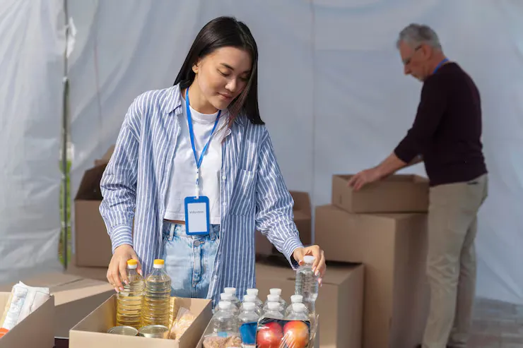 A volunteer packing bottles and supplies into boxes